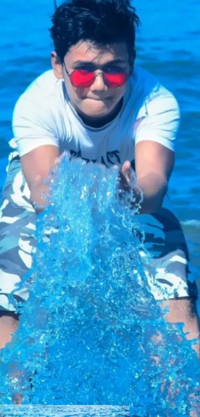 Man splashing blue water at the beach, wearing sunglasses.