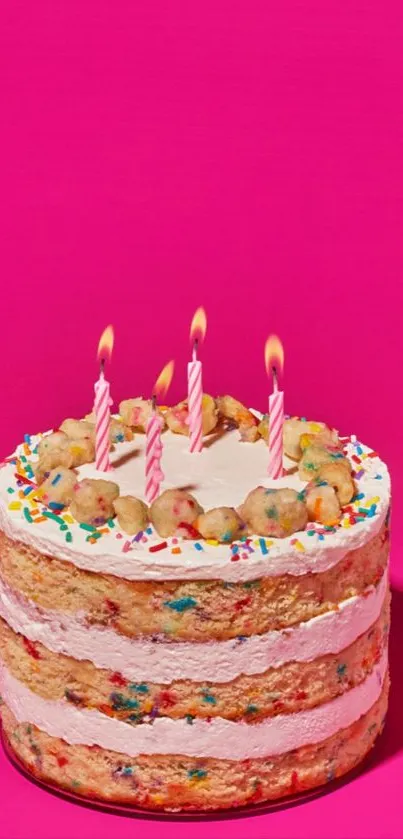 Colorful birthday cake with candles on a bright pink background.