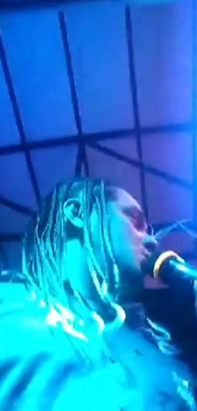 Performer singing under blue neon lights at a concert.