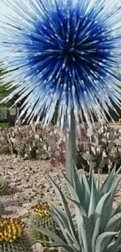 Vibrant blue glass sculpture in a cactus garden setting.