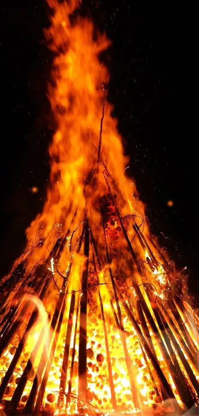 Fiery bonfire blazing under a dark sky creating a vibrant effect for phones.