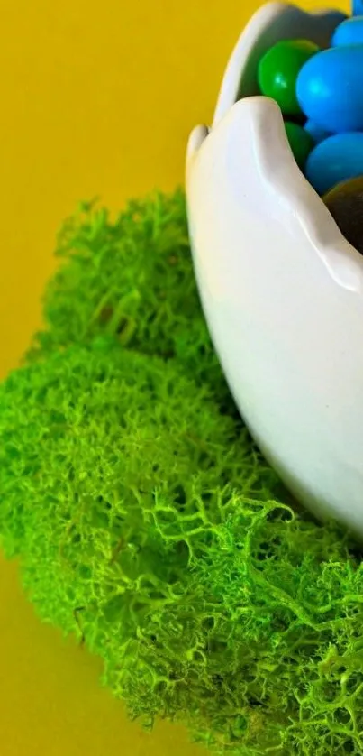 Egg-shaped bowl of colorful candies on a vibrant moss and yellow background.