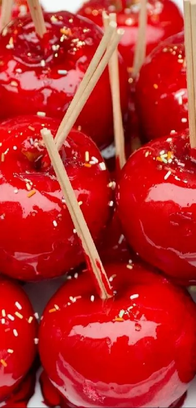 Red glossy candy apples with popsicle sticks.