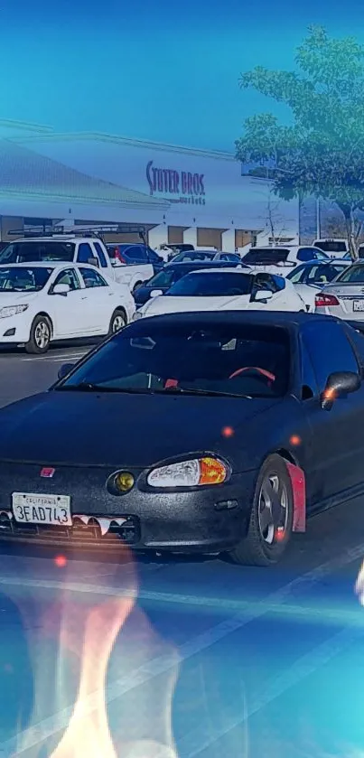 Black car with flames in a parking lot and blue sky.