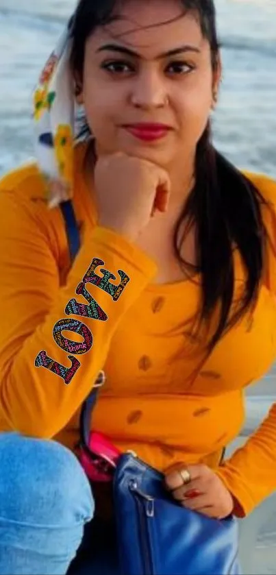 Woman in mustard top at the beach, posing with a scenic ocean backdrop.