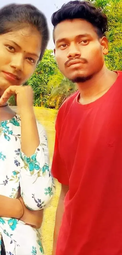 Couple posing outdoors with green background.