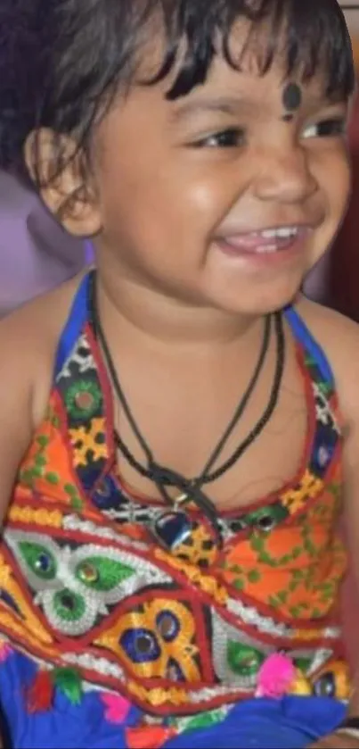 Smiling child in colorful traditional dress.