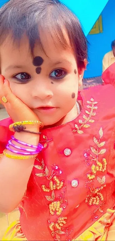 Colorful child in red traditional attire, charming look.