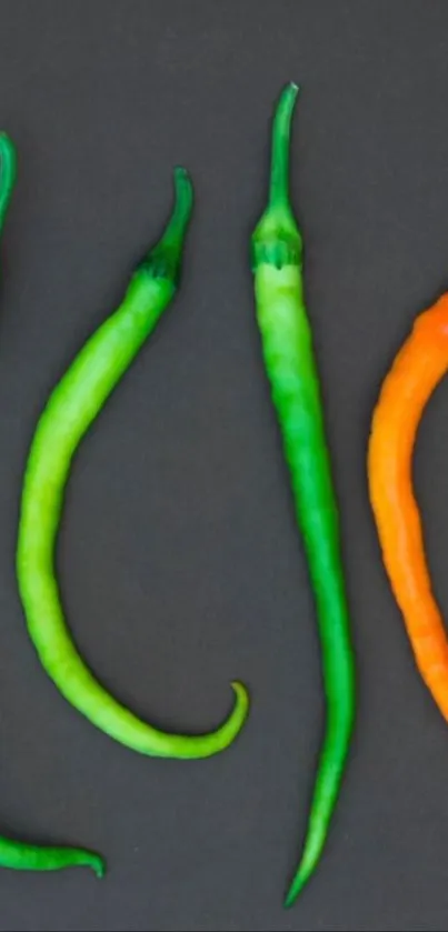 Vibrant green and orange chili peppers on a black background wallpaper.