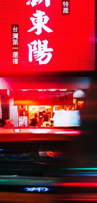 Urban street scene with vibrant red neon lights and busy night ambiance.