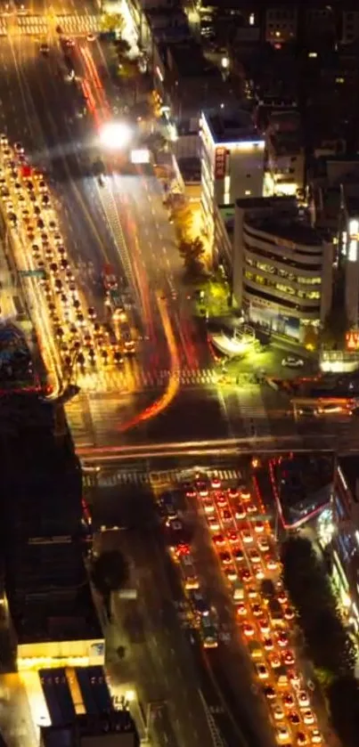 Aerial view of a city street illuminated with vibrant lights at night.