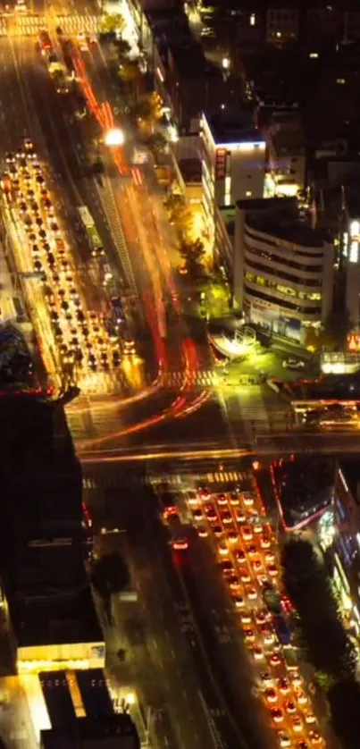 Aerial night view of a luminous city intersection with bright traffic.