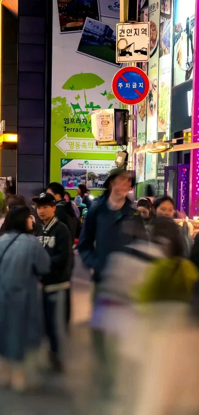 Vibrant city street scene at night with lit signs and bustling crowd.