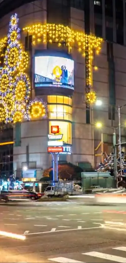 Nighttime city scene with festive Christmas lights decorating a building.