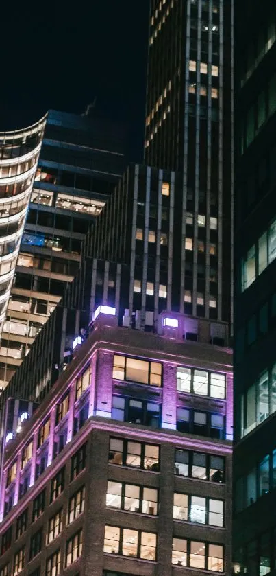 Night view of illuminated city skyscrapers showcasing urban architecture.