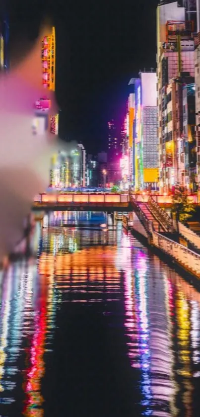 Vibrant neon-lit cityscape reflecting on a calm river at night.