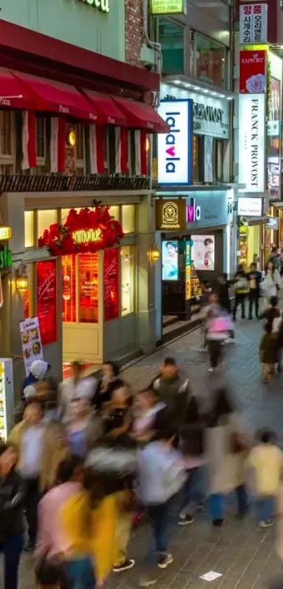 Busy city street at night with vibrant lights and bustling crowds.