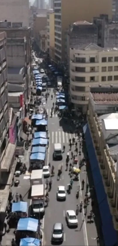 Aerial view of a busy city street with market stalls and pedestrians.