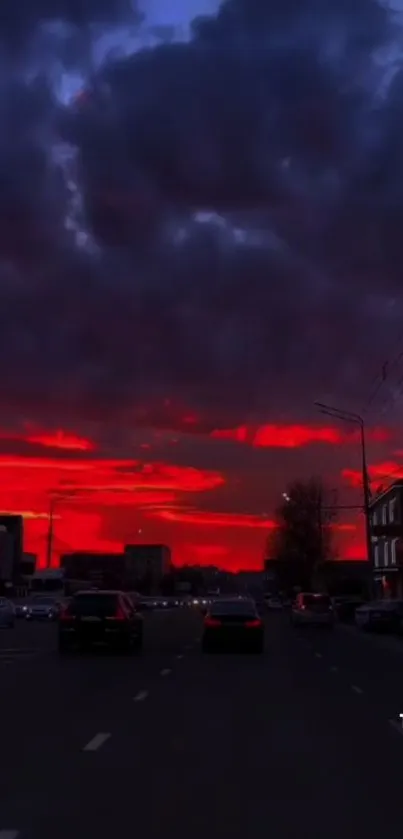 City skyline under a vibrant red sunset, framed by dramatic clouds.