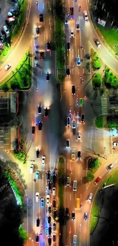 Aerial view of vibrant city intersection at night with colorful traffic lights.