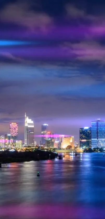 Vibrant city skyline at night with purple and blue lights reflecting on water.