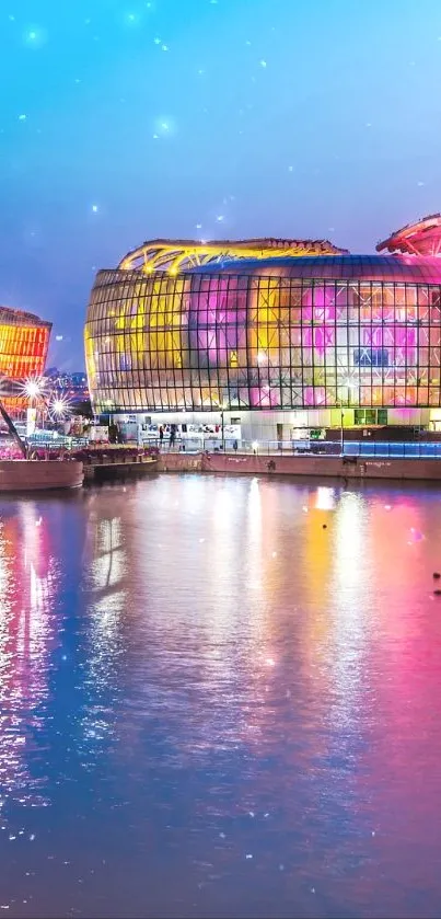 Illuminated buildings reflecting on water at night in a vibrant cityscape.