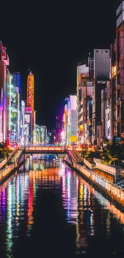 Vibrant cityscape with neon lights reflecting on a canal at night.