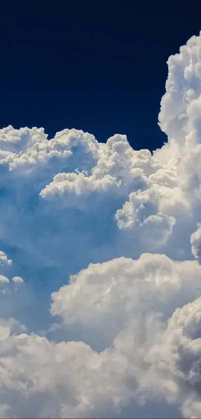 Fluffy clouds against a deep blue sky wallpaper.