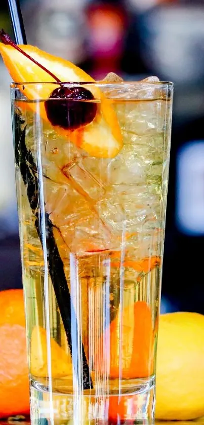 Colorful cocktail glass with citrus fruits in background.