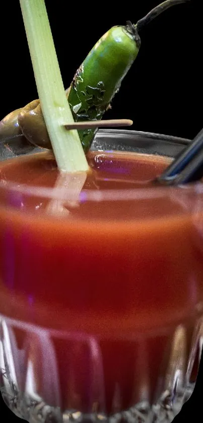 Red cocktail with lemongrass and chili garnish in a glass.