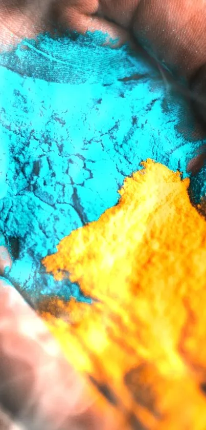 Hand covered in vibrant blue and orange powders on a mobile wallpaper.