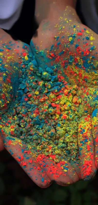 Hands holding vibrant colorful powder with orange, blue, and yellow streaks.