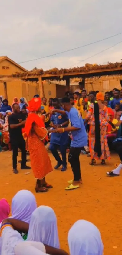 A lively community gathering in colorful traditional attire on a sandy ground.