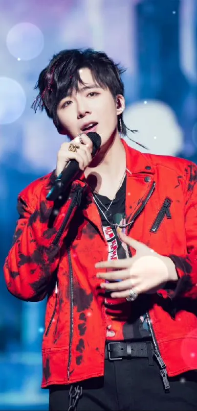 Performer in a vibrant red jacket on stage with a blurred cityscape backdrop.