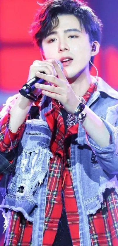 Energetic concert performer in a checkered fashion outfit on stage.