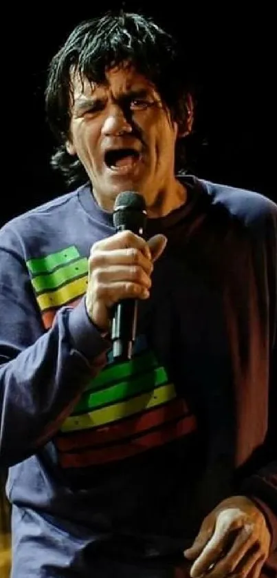 Concert singer passionately performing with colorful attire on stage.