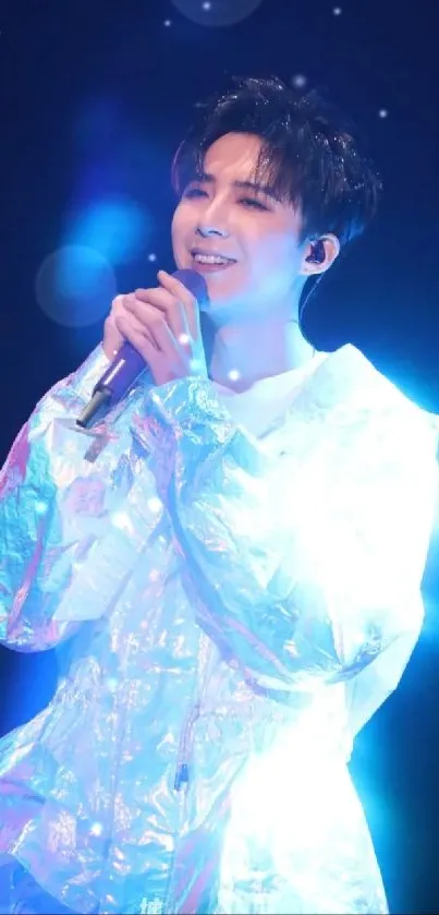 Singer with neon blue lighting on stage performing energetically.