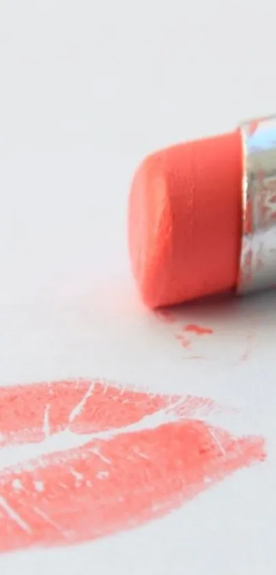 Coral lipstick with matching kiss mark on a white background.