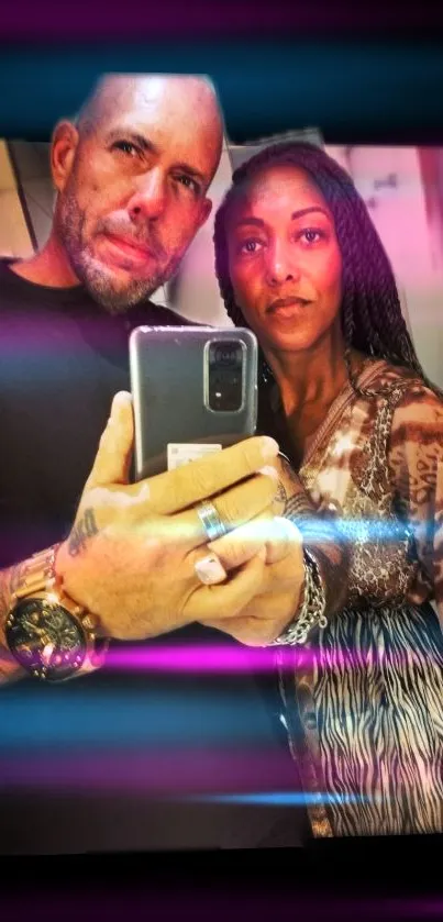 Stylish couple taking a neon-infused selfie with vibrant pink highlights.