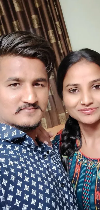 A vibrant selfie of a smiling couple with colorful outfits.