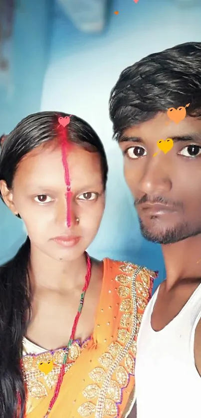 Vibrant couple portrait with colorful attire and a blue background.