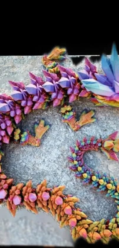 Colorful crystal dragon on gray stone background.