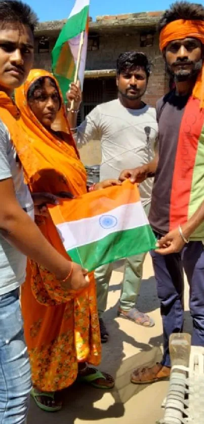 Group holding Indian flags in colorful attire, symbolizing celebration and unity.