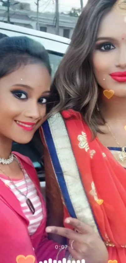 Two women in traditional attire with vibrant smiles on a festive occasion.