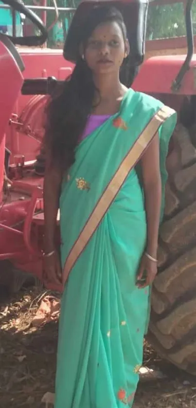 Woman in turquoise sari standing by a tractor