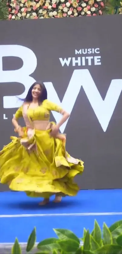 A dancer in vibrant yellow moves energetically on stage.