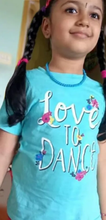 Child wearing blue 'Love to Dance' shirt, smiling brightly.