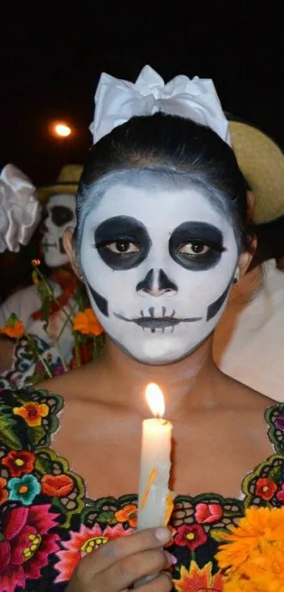 Day of the Dead celebration with face paint and candle.