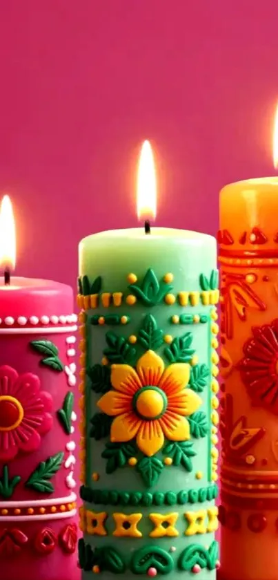 Three vibrant decorative candles with floral designs.