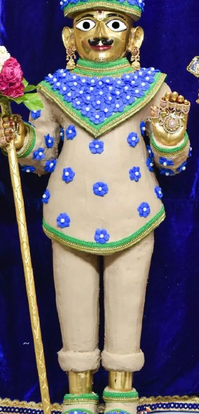 Colorful deity adorned with blue and gold standing against a dark blue backdrop.